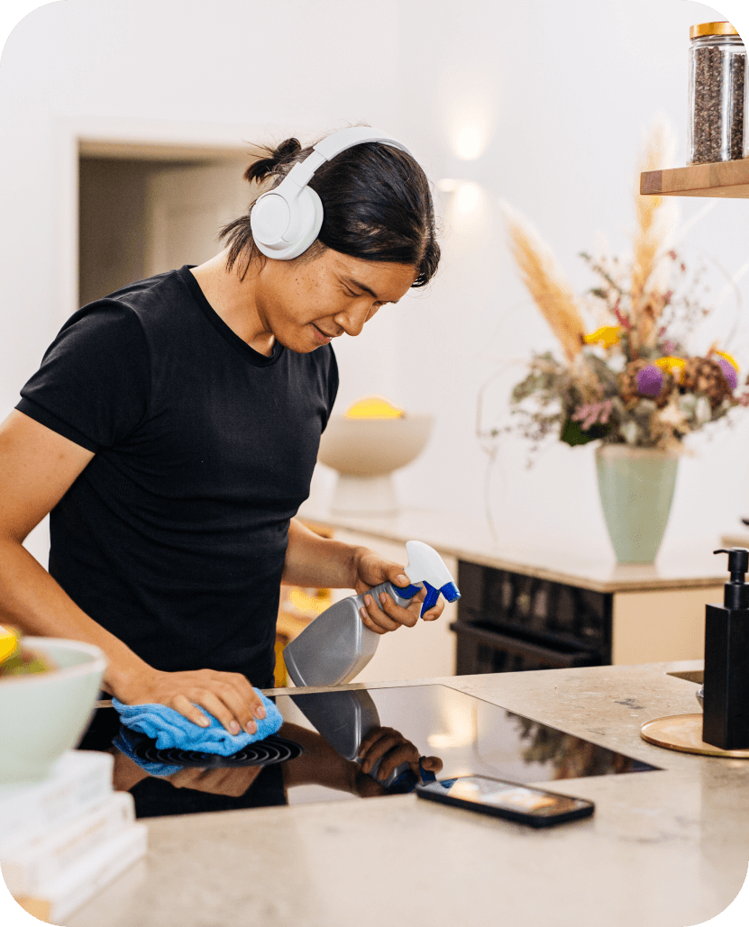 A person cleaning their kitchen whilst listening to blinks on Blinkist